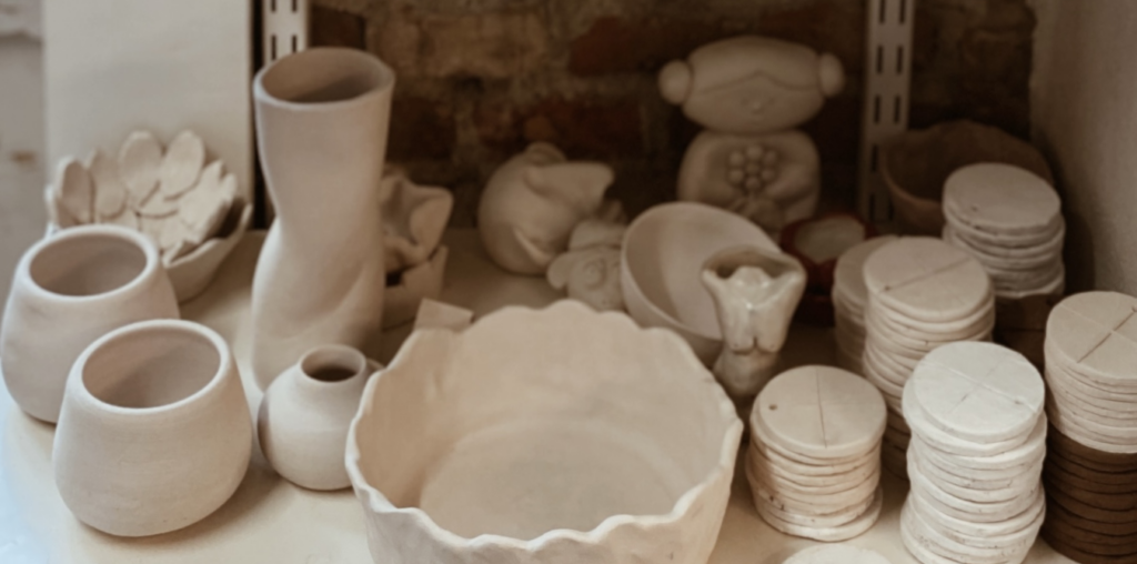 Diverse keramik potter og figurer på en hylde