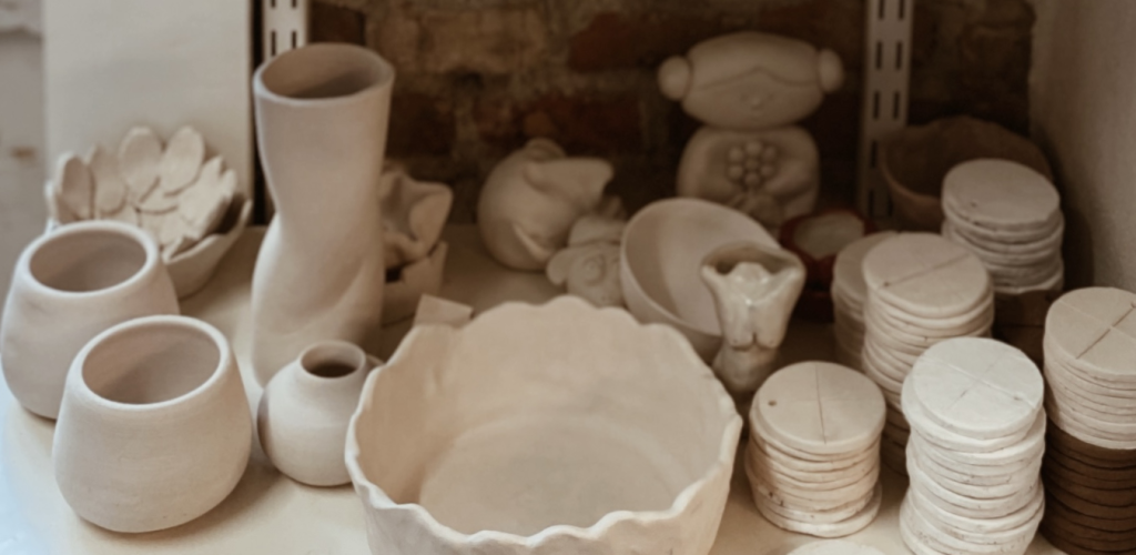 Diverse keramik potter og figurer på en hylde